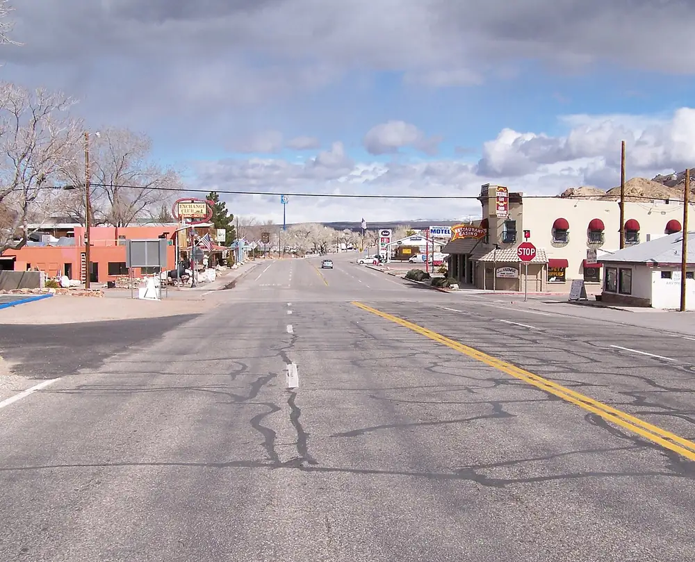 The main street of Beatty, Nevada along US 95 with motels and mountains behind.