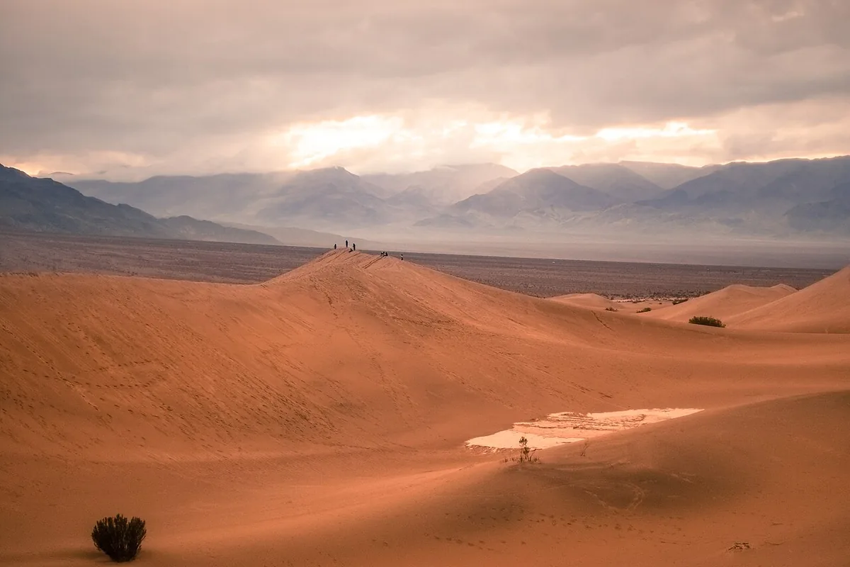 Sand dunes and distant mountains at sunset in Death Valley National Park.