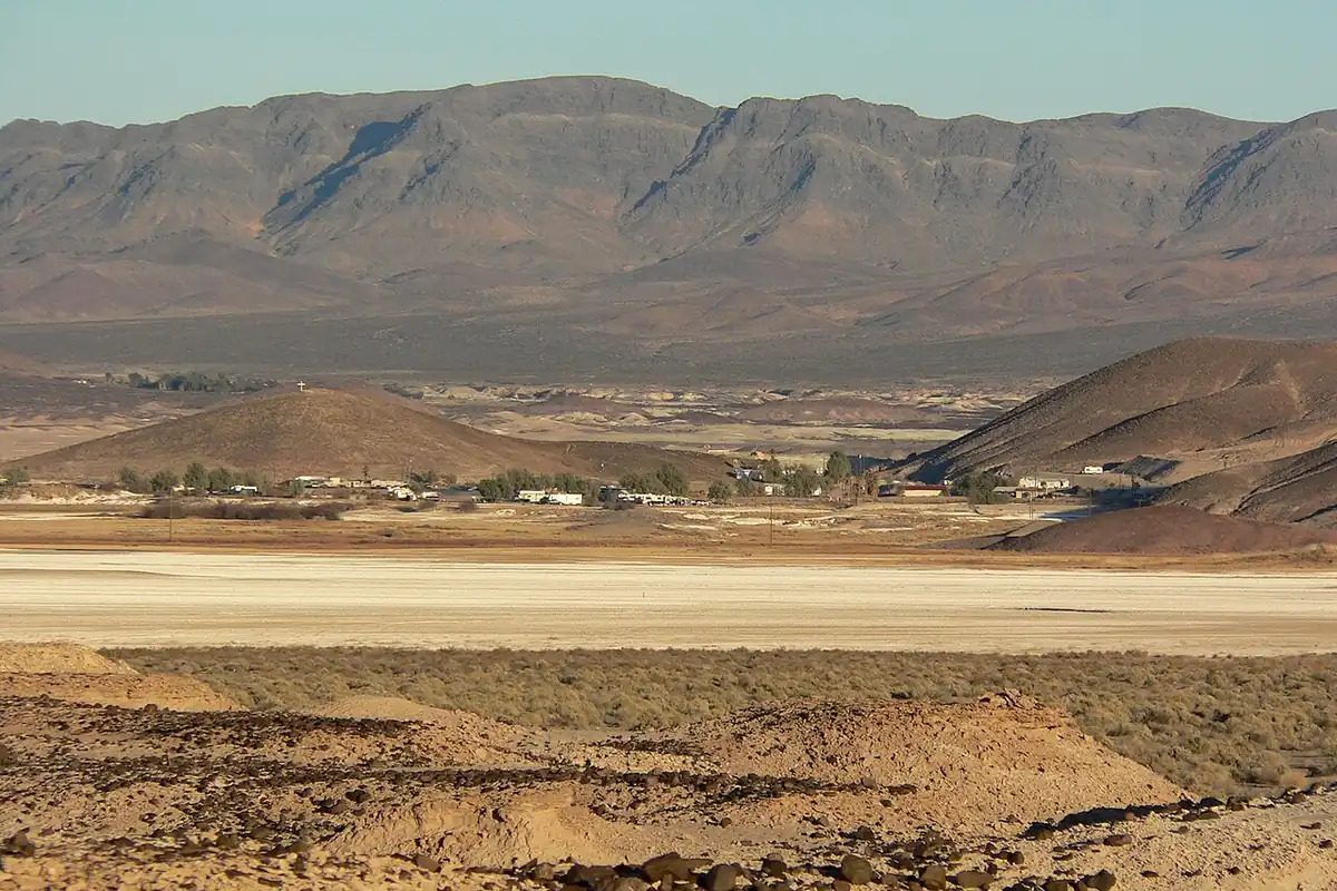 The Tecopa Hot Springs settlement on a dry lakebed below desert mountains.